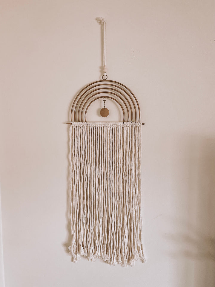 Close up of ivory and gold boho macrame wall hanger for By Two Fields